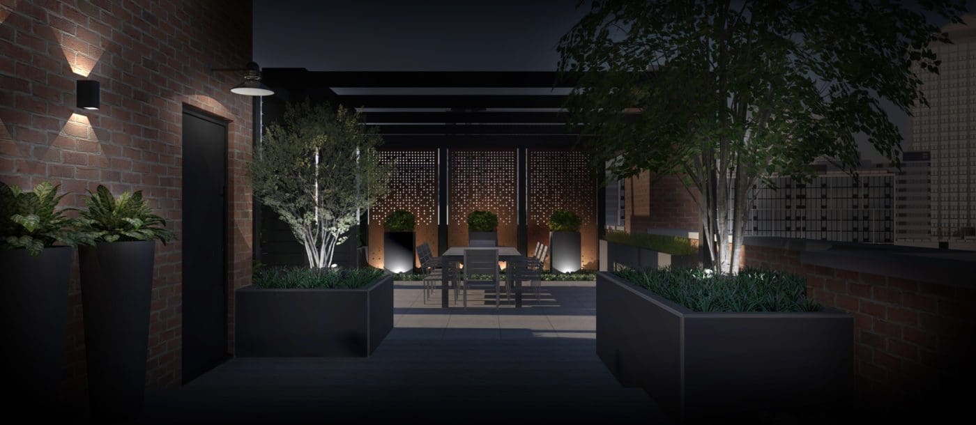 Outdoor patio at night with landscape lighting.