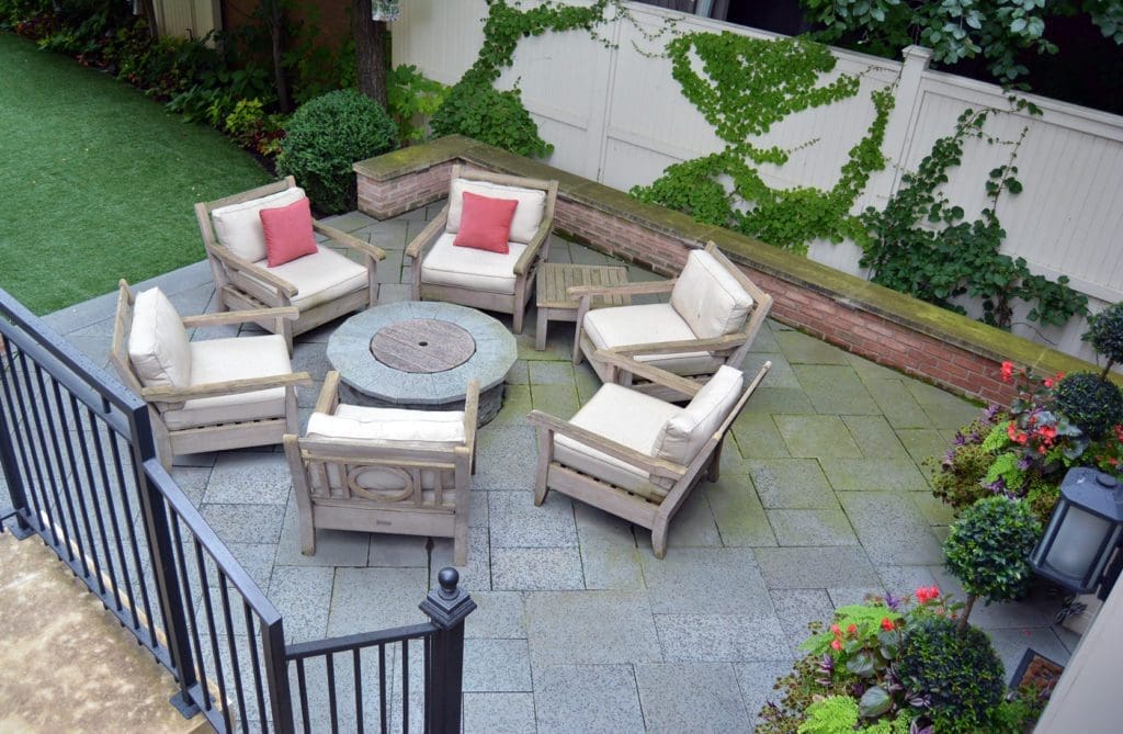 Ground level patio with seating area and round fire pit in the center.