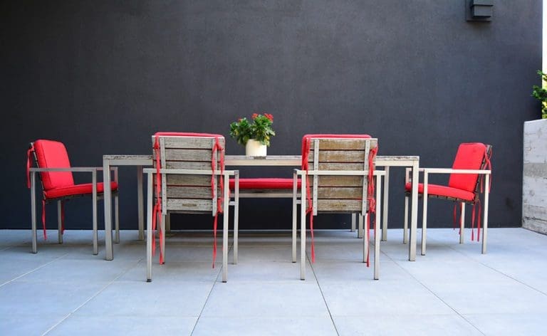 Patio dining table with red cushion on the chairs.