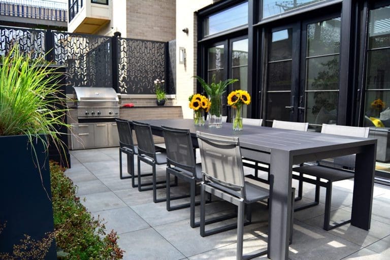 Outdoor dining area with privacy screen and grill area.