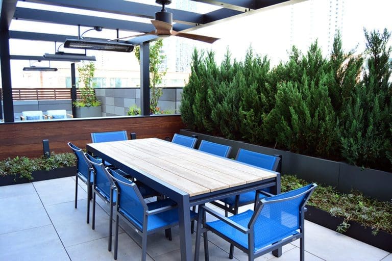 Outdoor dining table with blue chairs.