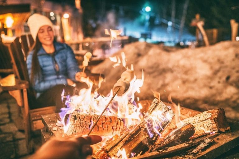 Close up of someone roasting marshmallows over a campfire.