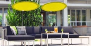 Outdoor sitting area with two round yellow umbrellas for shade.