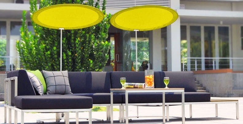 Outdoor sitting area with two round yellow umbrellas for shade.