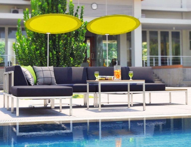 Outdoor sitting area with two round yellow umbrellas for shade.