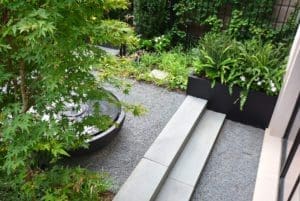 Outdoor cement stairs in a rock patio garden area.