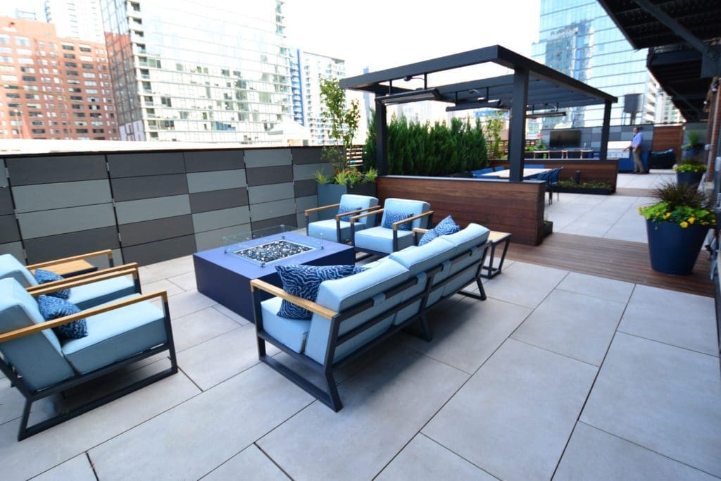 Porcelain Paving on a roof deck with seating, fire glass fire pit and pergola.