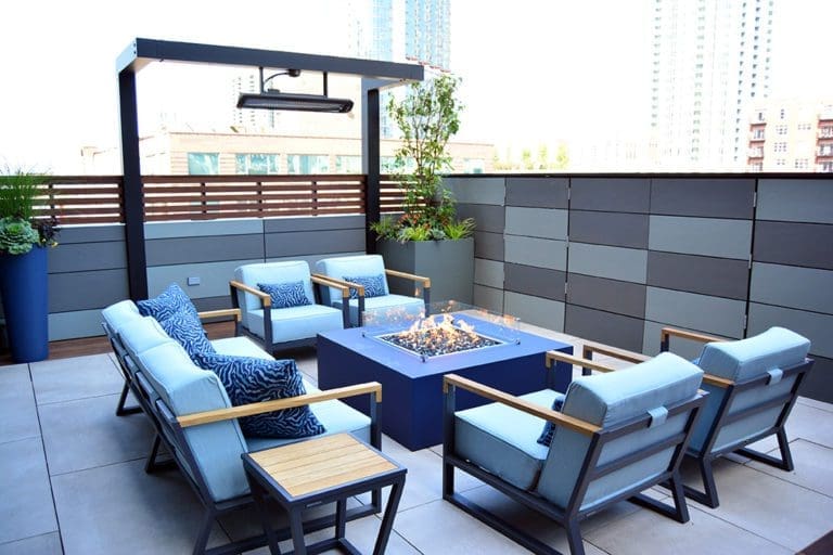 Patio with seating area around a square fire glass gas fire pit.
