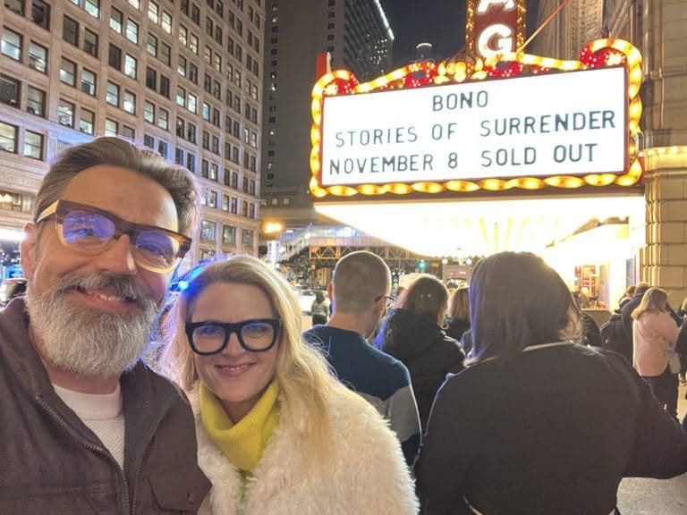 Craig and Sara in front of Bono concert sign.