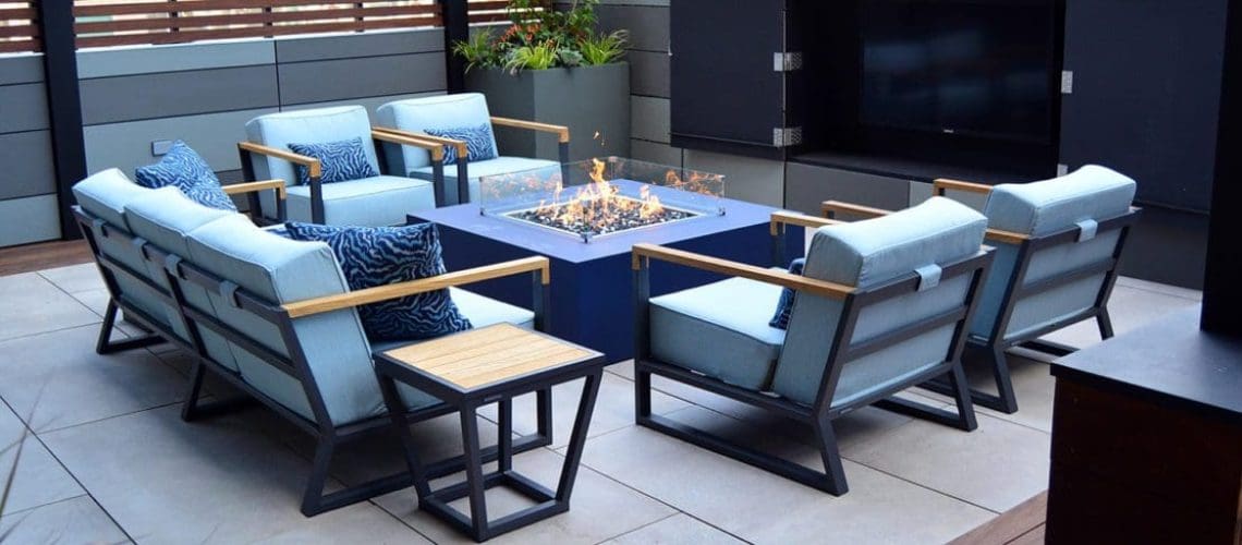 Patio with seating area around a square fire glass gas fire pit.