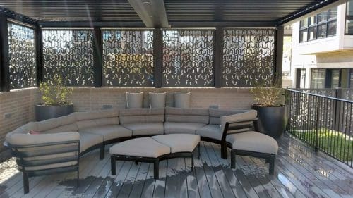 Curved seating area under a black metal pergola with a privacy screen.